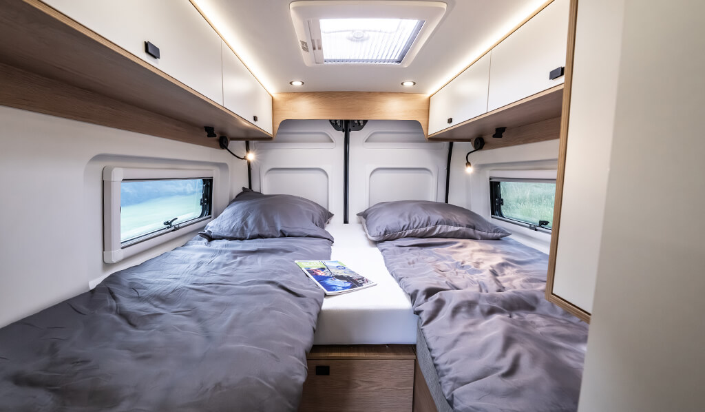 Les deux lits jumeaux à l’arrière peuvent facilement être transformés en un immense lit double où il fait bon se prélasser Les deux lits jumeaux à l’arrière peuvent facilement être transformés en un immense lit double où il fait bon se prélasser